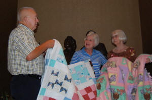 Glen , Andrea and Edna with Edna's quilt to be auctioned at MTSU game and a blanket for children staying in the Fisher House